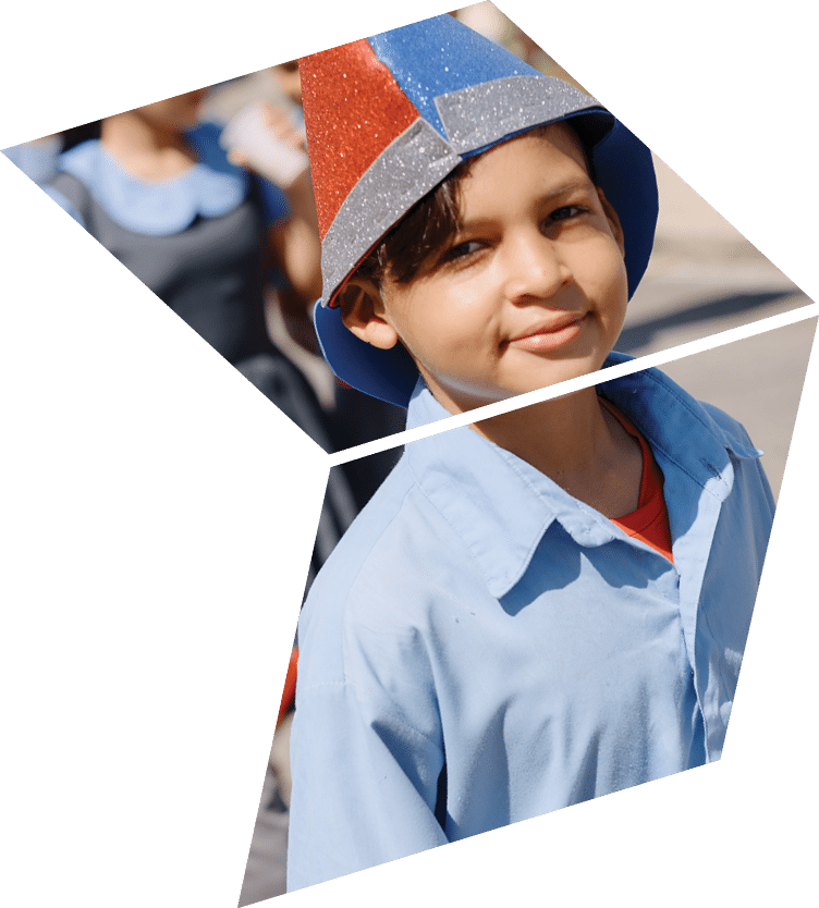 A young boy wearing a blue shirt and a red and blue hat. Description generated by AI